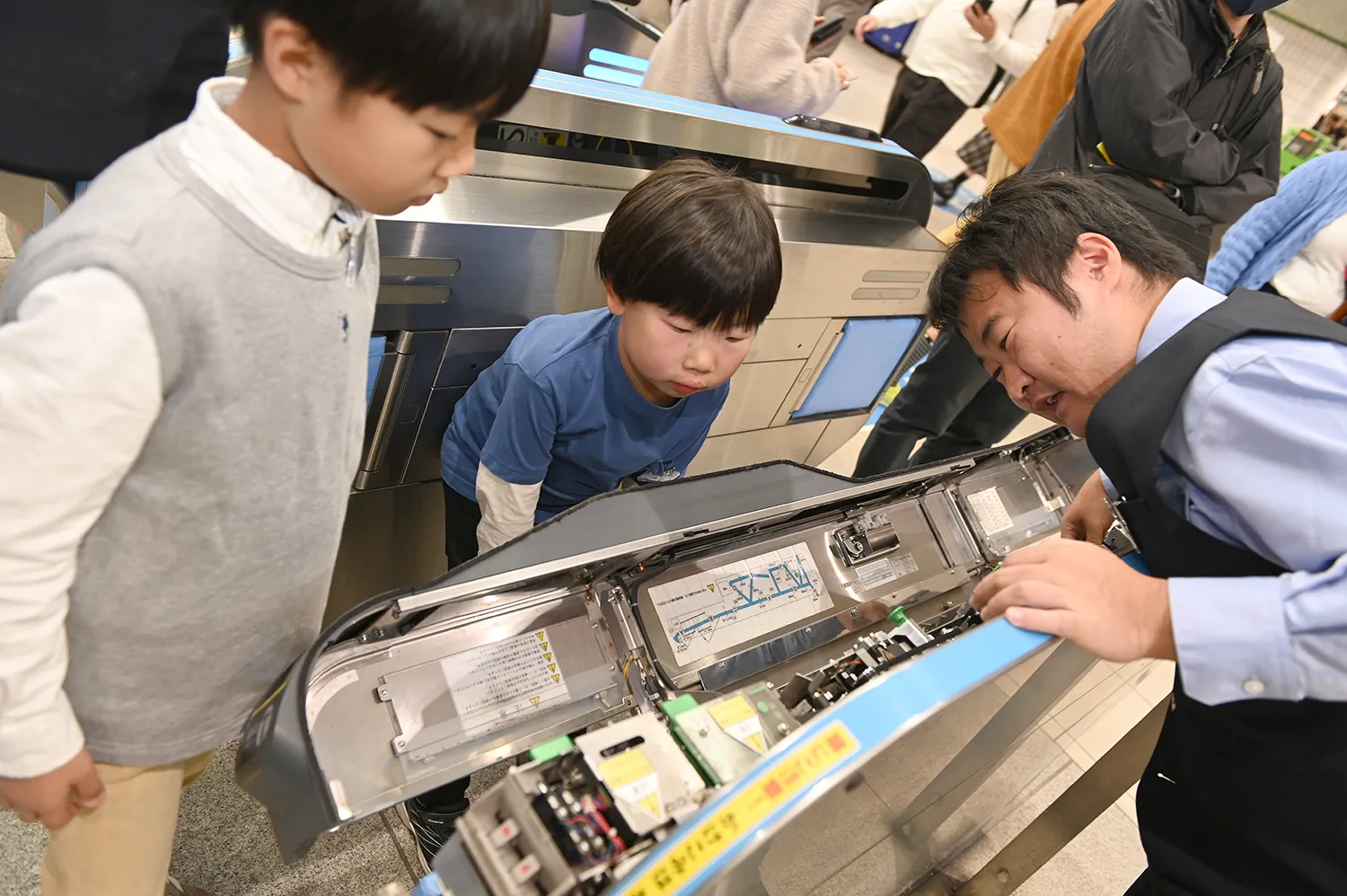 カバーが外された改札機の内部に、子どもたちは興味津々