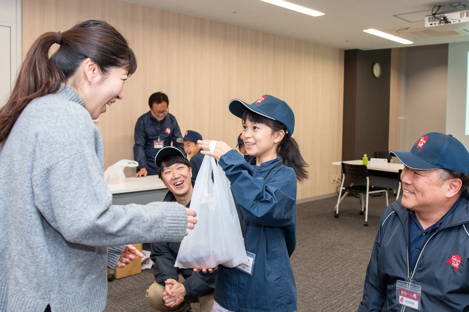 両手で丁寧に荷物を手渡しする子どもたち