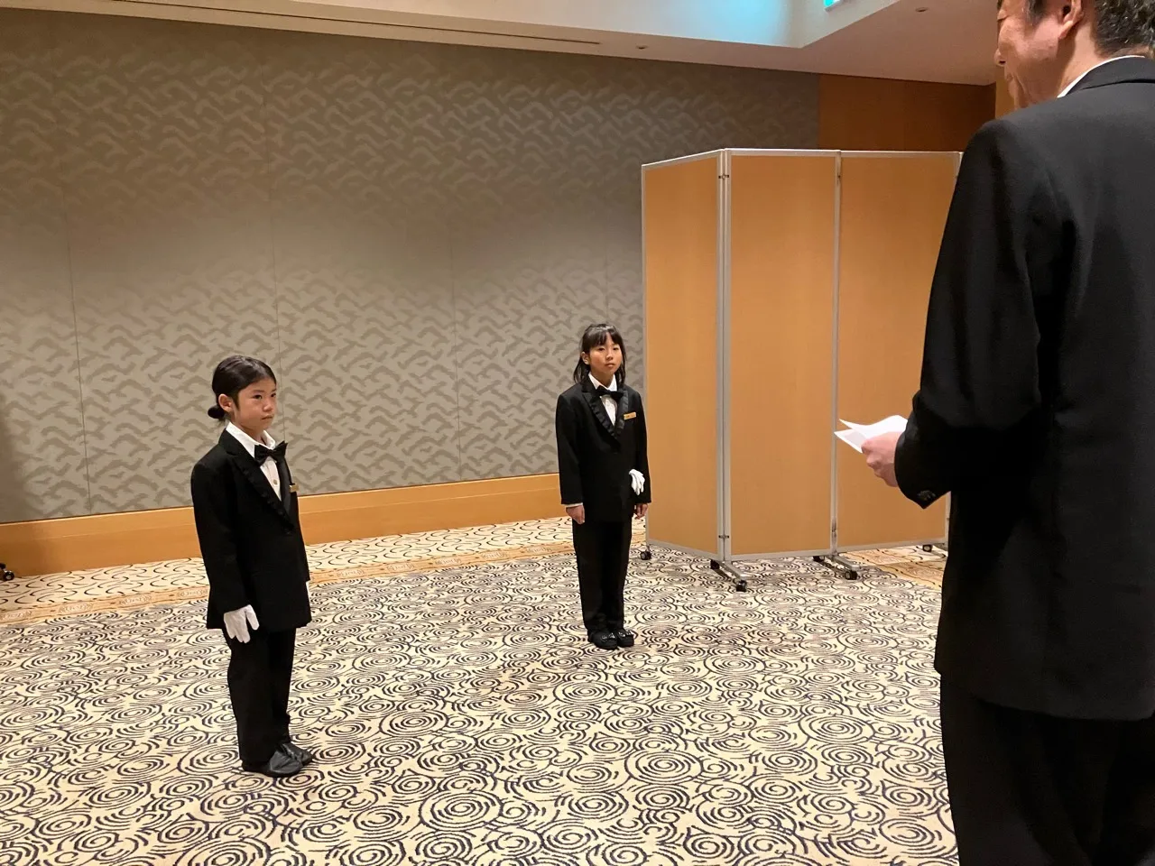 黒のタキシードと蝶ネクタイを身に着け、ビシッと決めた子どもたち