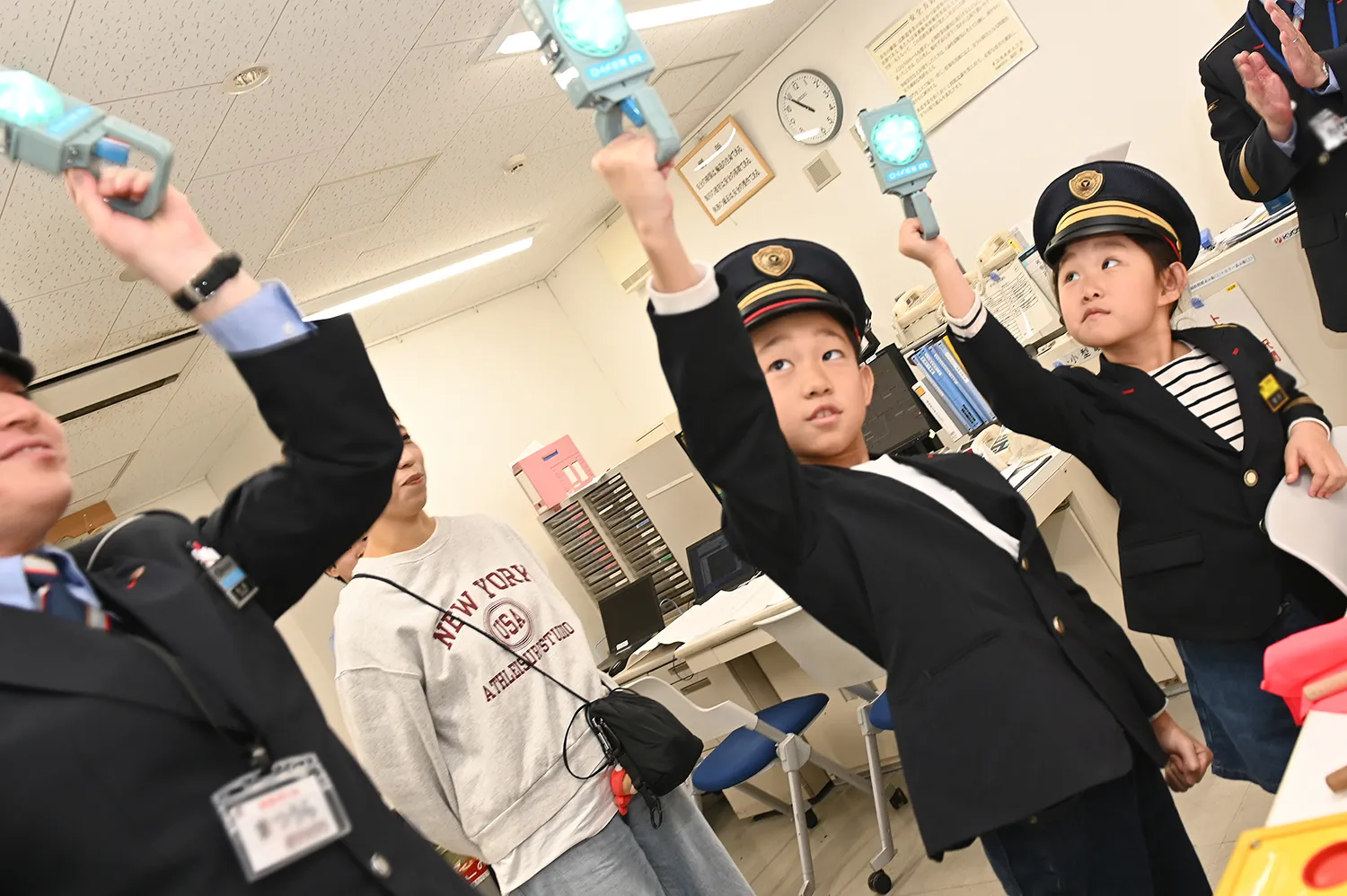 信号扱所を訪れ、手旗を振る練習をする子どもたち
