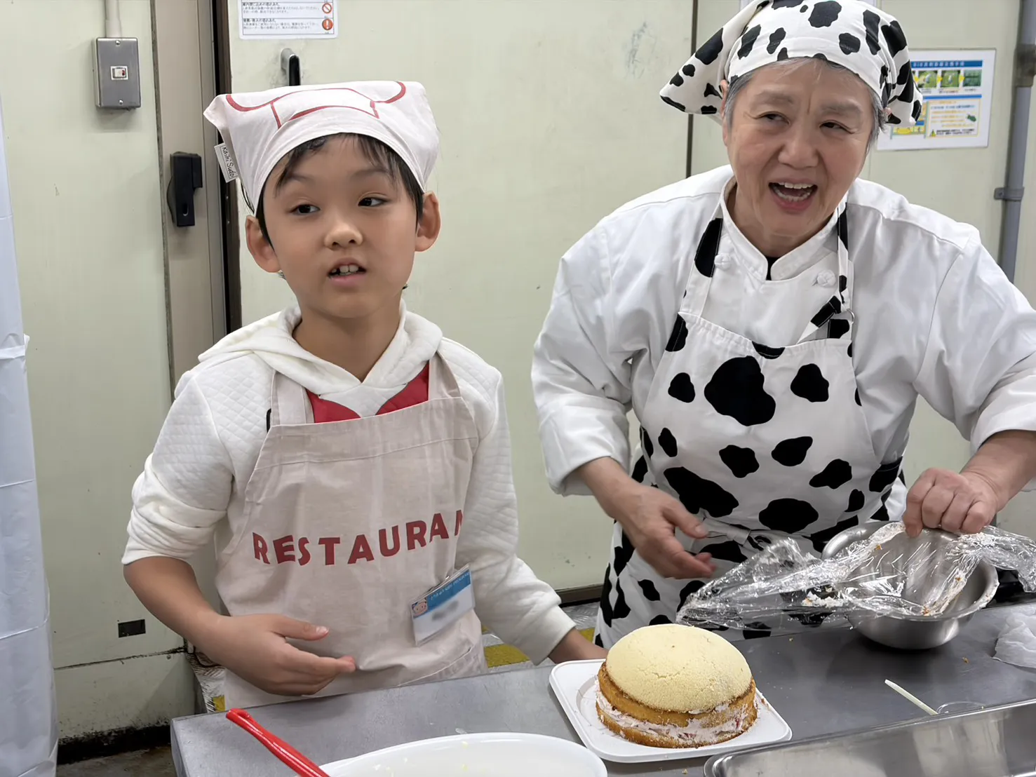 スライスしたスポンジケーキをボウルに入れ、クリームを塗ってスポンジを重ねていきます